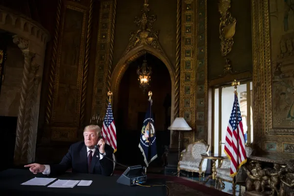 Trump taking a call and signing documents in Mar-a-Lago.